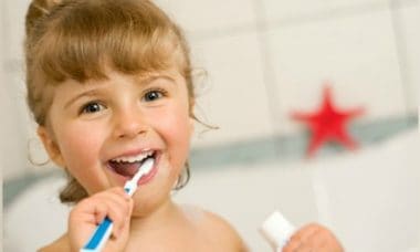 niña lavando sus dientes