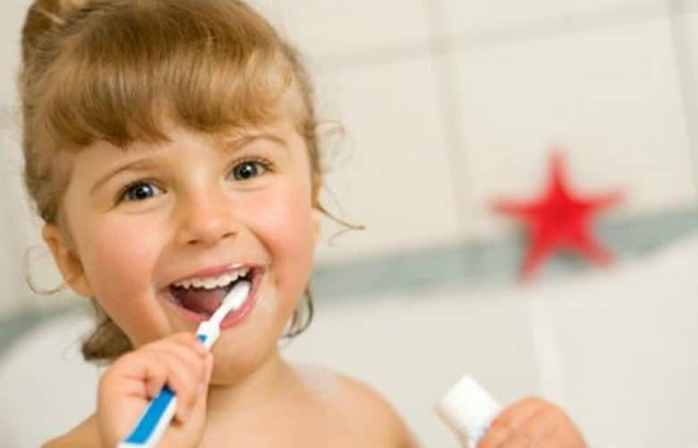 niña lavando sus dientes