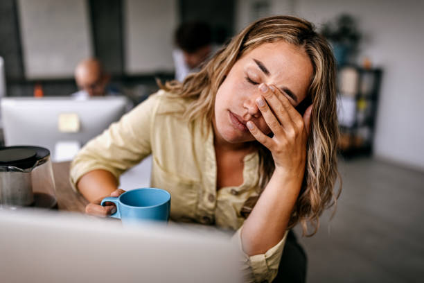 mujer cansada sentada en escritorio